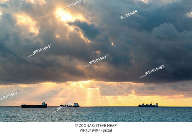 Three cargo freight ships on horizon