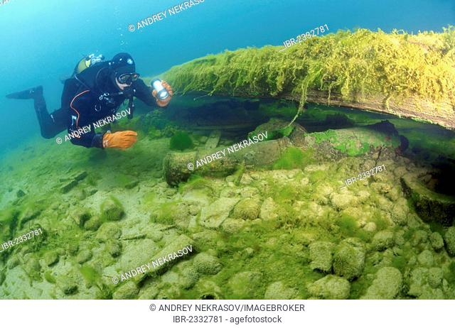 Diver examines an ancient gun found under water, Lake Baikal, Siberia, Russian Federation, Eurasia