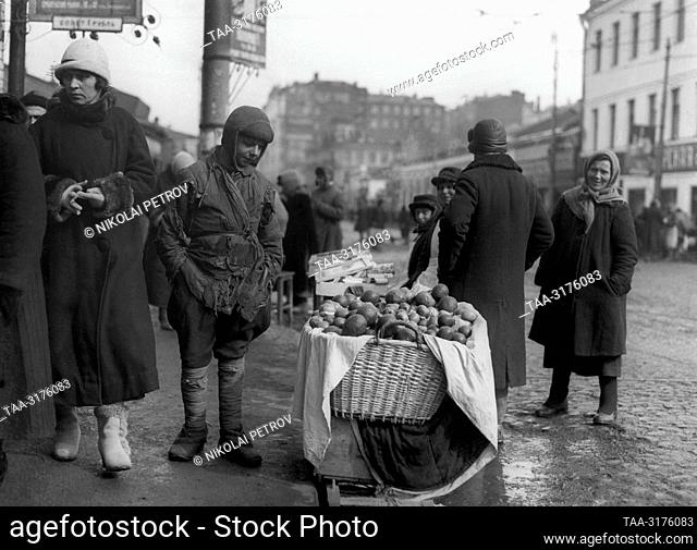 1921-1925. Russia. A homeless child looks at market stalls at the street market in Smolenskaya Square. The exact date of the photograph is unknown