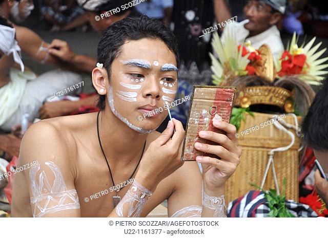 Denpasar (Bali, Indonesia): a Balinese adolescent putting on facial paintings at the Bali Arts Festival’s opening