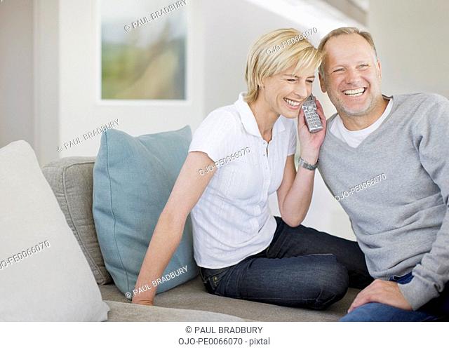Couple listening to cordless phone together