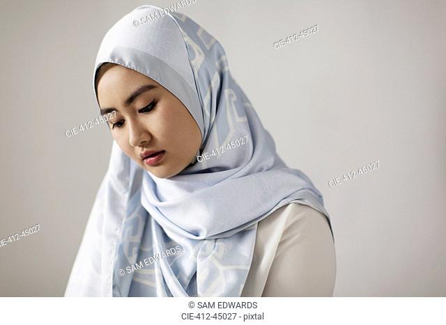 Serene young woman wearing blue silk hijab