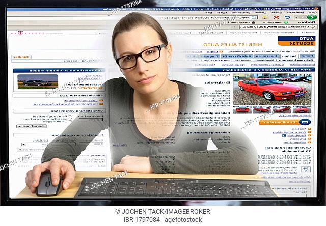 Young woman sitting at a computer surfing the Internet, viewing a page for buying and selling vehicles, autoscout24.de, view from within the computer