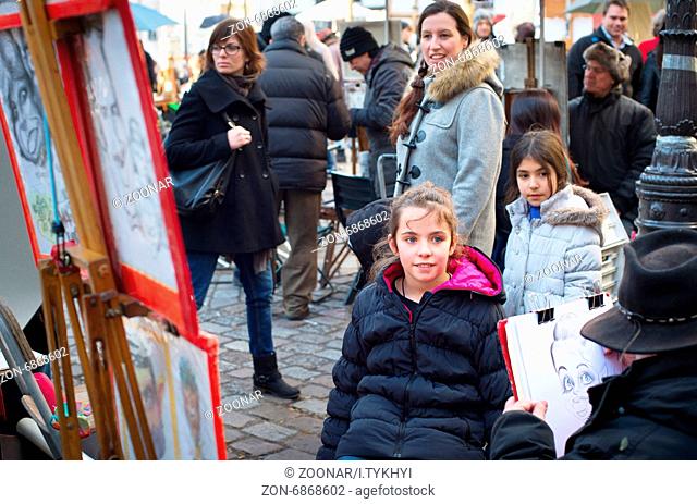 PARIS, FRANCE - JAN 17, 2015: Unidentified artist drawing a portrait of the tourist at Place du Tertre, Montmartre. Place du Tertre is now an open-air workshop...