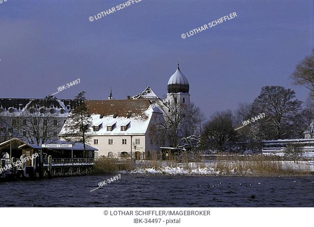 View to Frauenchiemsee monastery and pier on snow covered Fraueninsel in lake Chiemsee; Bayaria, Germany