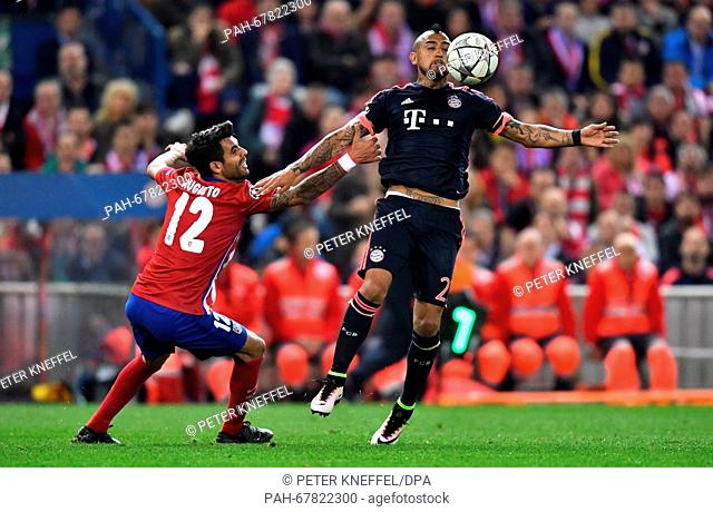 Munich's Arturo Vidal (R) and Madrid's Augusto Fernandez vie for the ball during the Champions League semi-final match between Atletico Madrid and Bayern Munich...