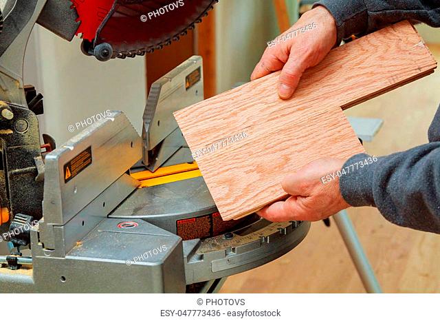 Construction worker, Trimming parquet on using circular miter saw for cutting