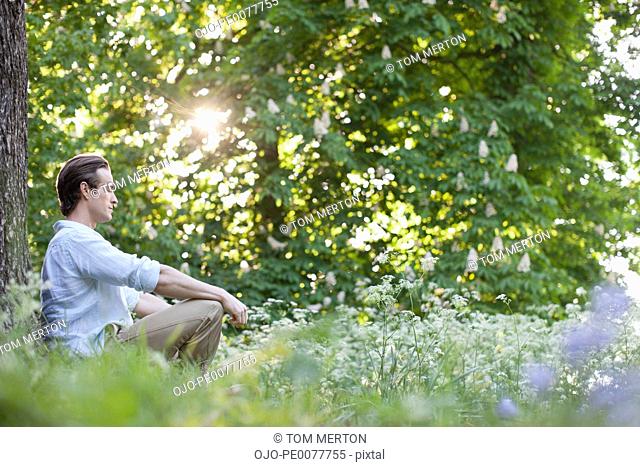 Man meditating in field of flowers