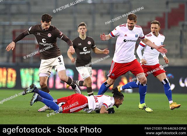 01 March 2021, Hamburg: Football: 2. Bundesliga, Matchday 23 FC St. Pauli - Hamburger SV at Millerntor-Stadion. Jeremy Dudziak (bottom) goes down after a duel...