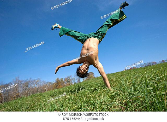 One arm handstand in field