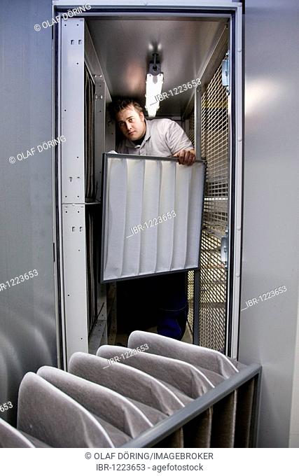 Master Craftman for plumbing student in the heating, ventilating, and air conditioning, HVAC laboratory, changing the filter in an air conditioner