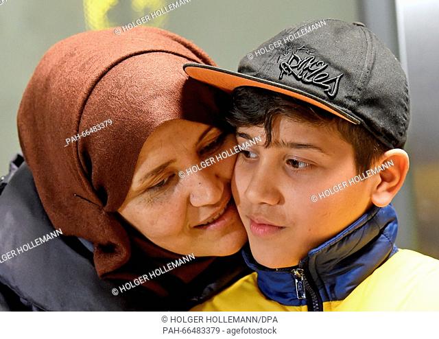 Afghan refugee boy Mahdi Rabani stands cheek-to-cheek with his mother Shockria in the arrivals hall of the Hanover-Langenhagen Airport with a bouquet of flowers...