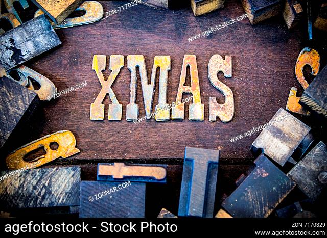 The word XMAS written in rusted metal letters surrounded by vintage wooden and metal letterpress type