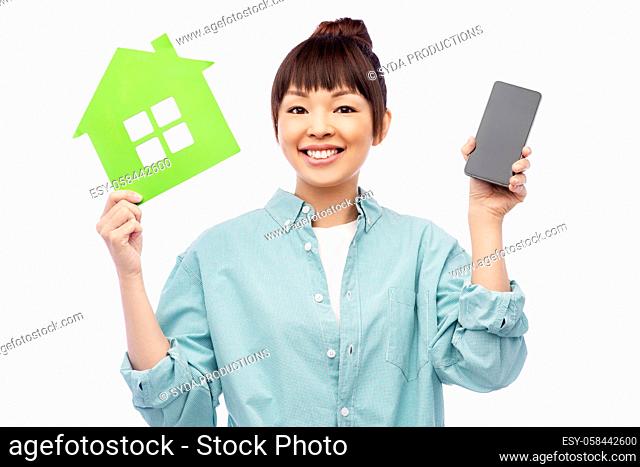 smiling asian woman holding green house