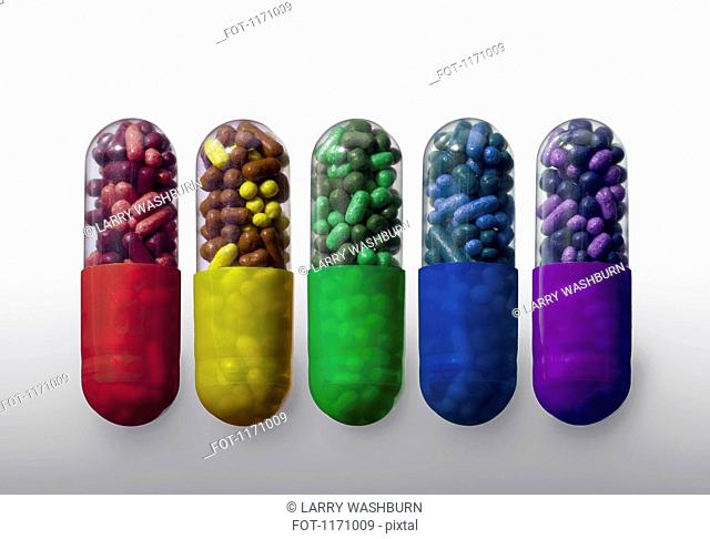 A row of vibrantly variously colored capsule pills, close-up