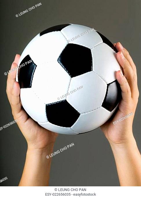 Hand holding soccer ball