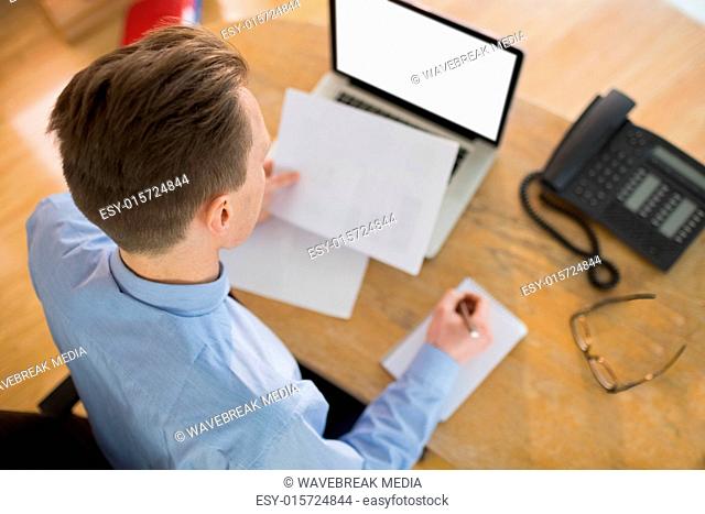 Focused businessman reading document at desk