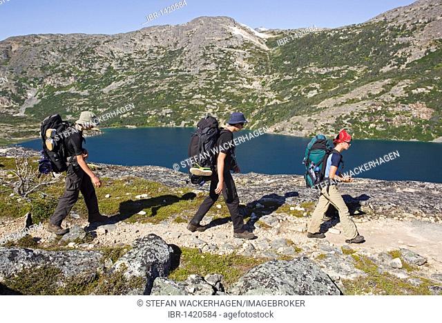 Group of young hikers hiking, backpacking, backpack, historic Chilkoot Pass, Chilkoot Trail, near Happy camp, Long Lake behind, alpine tundra, Yukon Territory