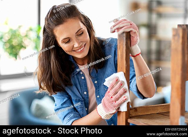 woman cleaning old table surface with tissue