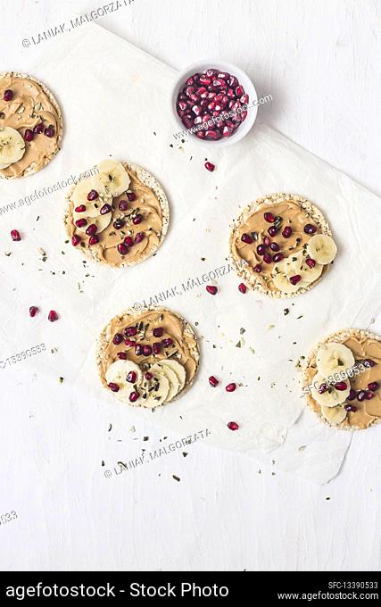 Rice crackers with peanut butter, banana and pomegranate