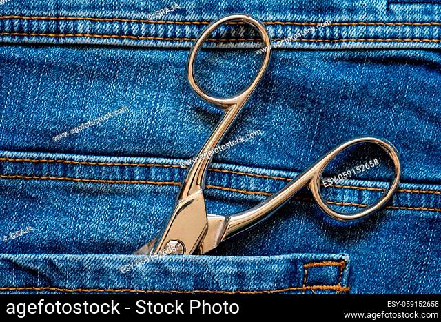 Tailor scissors in blue jeans pocket, close up