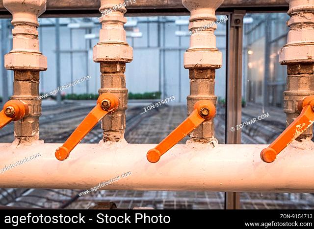 Factory pipes with orange handles for regulation of water