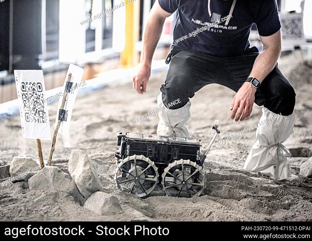 20 July 2023, Mecklenburg-Western Pomerania, Rostock-Laage: Development engineer Max Manthey from Neurospace GmbH sets up a lunar rover for a ride on a test...