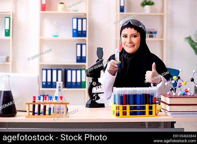 The female chemist in hijab working in the lab