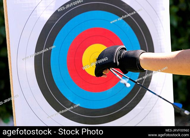 Woman removing arrows from bull's eye