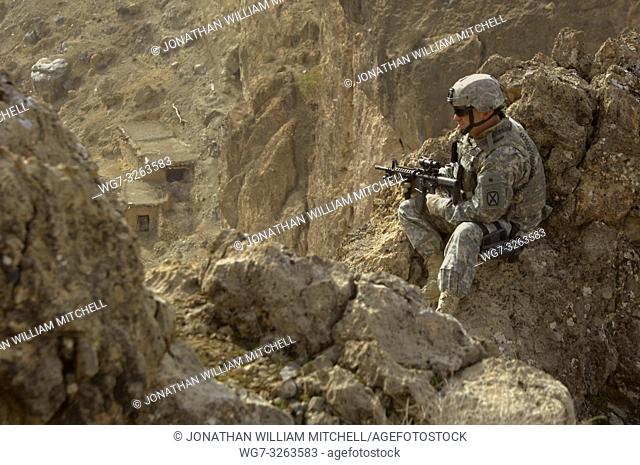 AFGHANISTAN Mandikowl -- 23 Dec 2006 -- US Army Staff Sgt Aldridge looks over a cliff as he provides security while his fellow soldiers