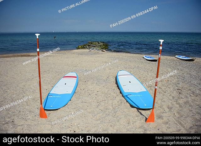 09 May 2020, Schleswig-Holstein, Timmendorfer Strand: Two surfboards of a surf school are waiting for the students in Niendorf on the beach on the sand