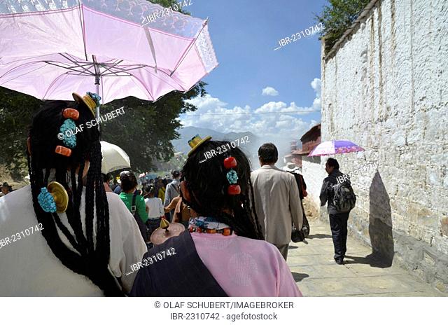 Tibetan Buddhism, Tibetan women with a traditional headdress and parasol at the revealing of the Buddha image, at the Shoton or Choedoen or Yoghurt Festival