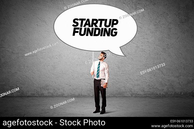 Young business person in casual holding road sign with STARTUP FUNDING inscription, new business idea concept