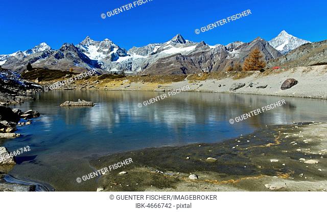 Frozen mountain lake Grüensee, also Grünsee, mountain landscape with f.l.t.r. Dent Blanche, Ober Gabelhorn, Gabelhorngletscher, Wellenkuppe, Triftgletscher