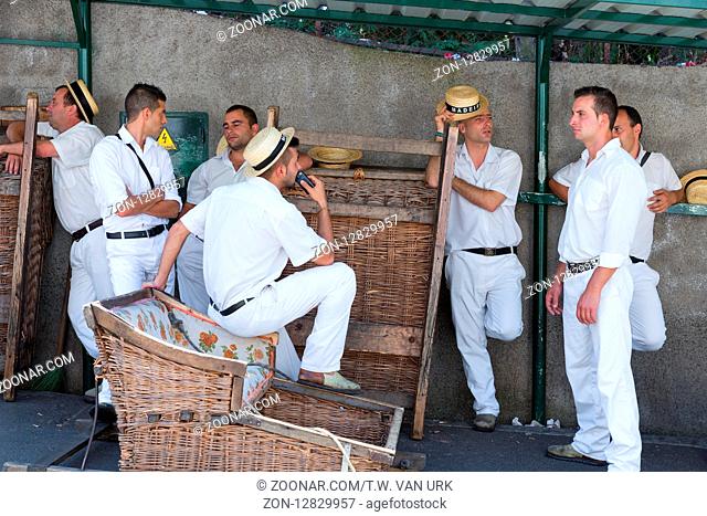 FUNCHAL, MADEIRA - AUG 13: Toboggan riders waiting for tourists on August 13, 2014 in Madeira, Portugal. Cane sledges were used as traditional local transport...