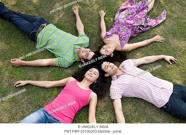 Friends lying in a huddle in a lawn