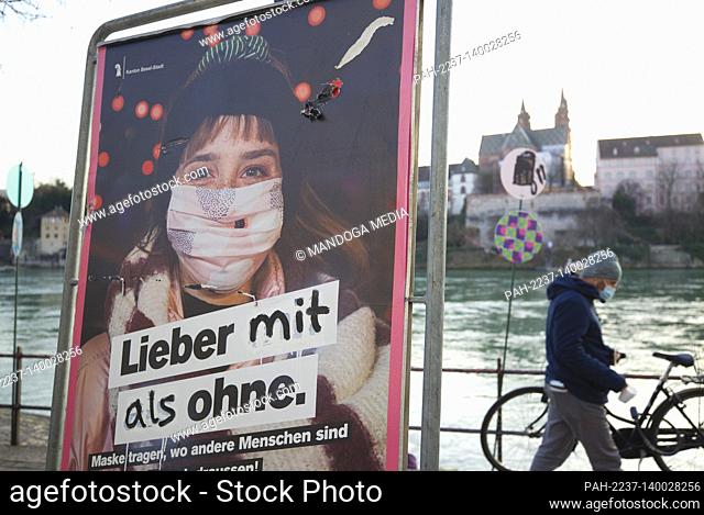 Basel, Switzerland - February 19, 2021: Spring Atmosphere despite Coronavirus. People are strolling outside and wearing Masks