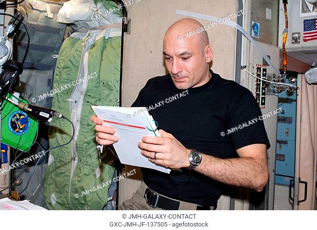 European Space Agency astronaut Luca Parmitano, Expedition 37 flight engineer, reads a procedures checklist in the Zvezda Service Module of the International...