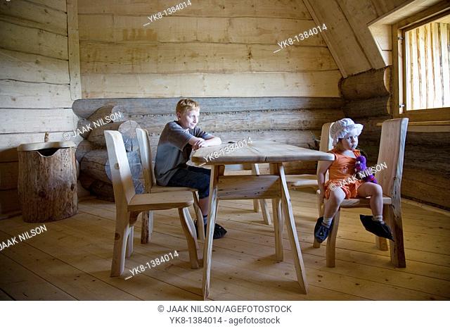 Serious Emorional Kids, Boy and Girl Sitting at Wooden Table in Old Blockhouse