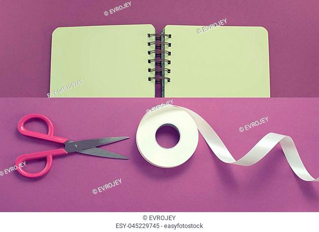 Collage Scissors and roll of tape in white on a purple background Opened the diary Materials for art, Hobby and design. Flat top view