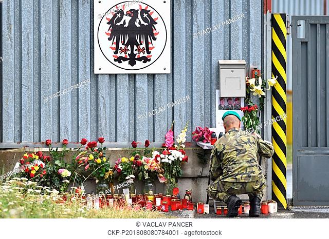 People lay flowers and lit candles by entrance to a base of 42th Mechanized Battalion in Tabor, Czech Republic, on August 6, 2018