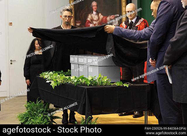 26 May 2023, Baden-Württemberg, Mannheim: The mummified heads are wrapped in gray boxes with a black cloth as part of a procession for the handover ceremony