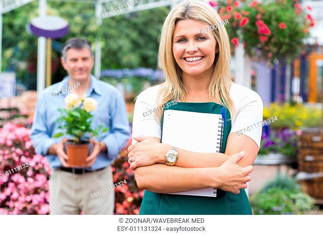 Woman holding a notepad with customer holding potted plant