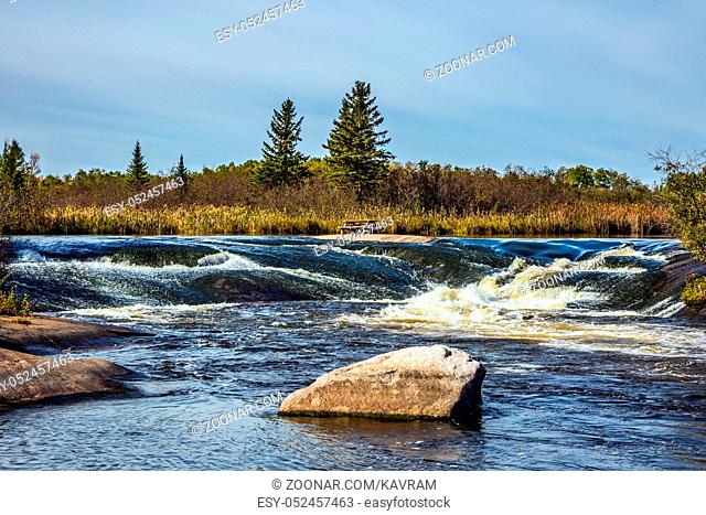 Foam water rapids on the smooth stones of the Winnipeg River. Old Pinawa Dam Provincial Heritage Park. The concept of travel
