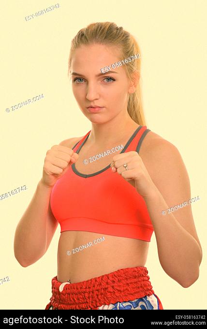 Studio shot of young beautiful teenage girl muay thai fighter ready to fight