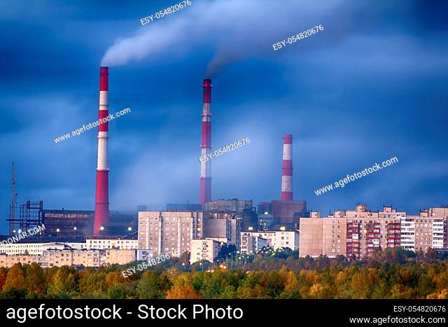 Night view of the metallurgical plant in the North. Smokes from pipes and many lights in the satellite city