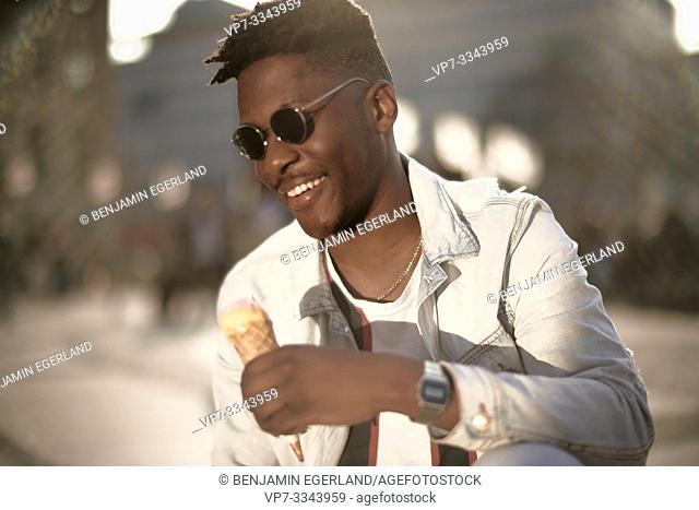 young African man holding ice cream, in Munich, Germany