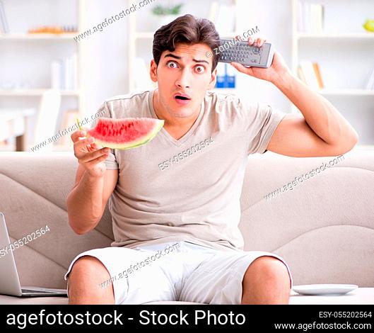 The man eating watermelon at home