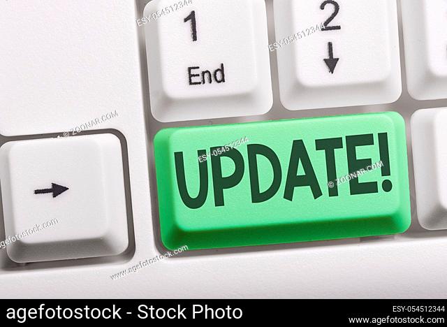 Text sign showing UPDATE. Business photo showcasing make something more modern or up to date like software program White pc keyboard with empty note paper above...