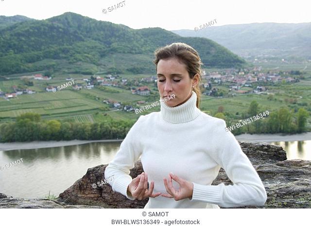 Young woman practising yoga an a mountain, Mudra
